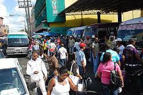Ciudadanos acuden a paradas de autobuses para dirigirse al exterior de Santo Domingo