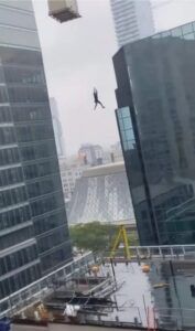 Obrero grita desesperado mientras cuelga en el aire de la grúa de un edificio