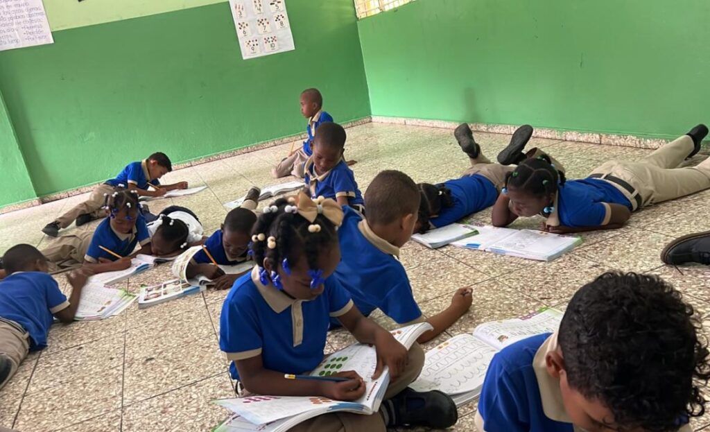 Niños toman clases en el suelo falta de butacas en escuela del Km 12 de Haina
