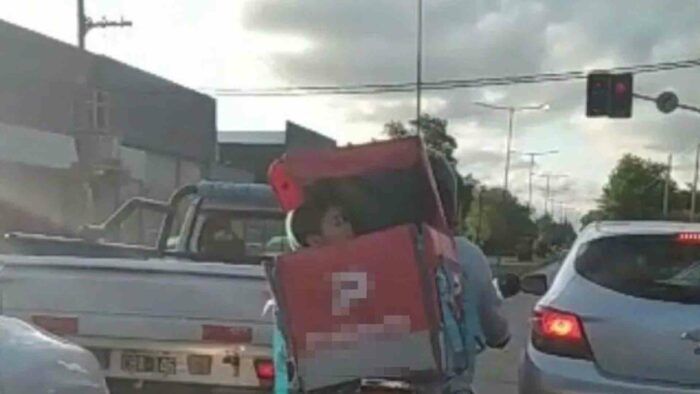 Repartidor lleva hijo en caja de delivery de su moto porque no tiene con quién dejarlo