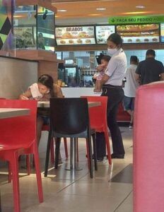 Gerente carga niño mientras su madre llena solicitud de empleo